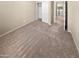 Cozy bedroom with neutral-toned walls and carpeting, and a closet with sliding doors at 15369 W Wethersfield Rd, Surprise, AZ 85379