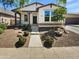 Charming single-story home with manicured desert landscaping and a covered front porch at 15369 W Wethersfield Rd, Surprise, AZ 85379