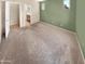 Spacious main bedroom features neutral carpeting and a view of the en-suite bathroom at 15369 W Wethersfield Rd, Surprise, AZ 85379