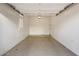 Empty garage with light tan epoxy floor, white walls, shuttered window, and open door, awaiting your car or storage at 1713 W Calle Marita --, Phoenix, AZ 85085