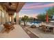 Outdoor living area with covered patio, pool, lounge chairs, dining table and chairs, desert landscape, and mountain views at 1713 W Calle Marita --, Phoenix, AZ 85085