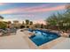 Backyard swimming pool with spa, fire pit, and lounge chairs against a vibrant desert sunset backdrop at 1713 W Calle Marita --, Phoenix, AZ 85085
