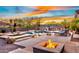 Backyard oasis offers a pool, spa, fire pit, and outdoor bar area, set against a colorful sky at 1713 W Calle Marita --, Phoenix, AZ 85085