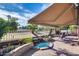 Landscaped backyard featuring mature trees, a cozy patio, and a custom water feature at 17162 N Winding Trl, Surprise, AZ 85374
