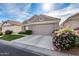 Charming home with a two-car garage, verdant lawn, and blooming flowers at 17162 N Winding Trl, Surprise, AZ 85374