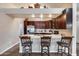 Kitchen featuring dark wood cabinetry, stainless steel appliances, and a breakfast bar with seating at 17162 N Winding Trl, Surprise, AZ 85374