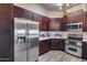 Well-equipped kitchen with stainless steel refrigerator and oven next to rich, dark cabinets at 17162 N Winding Trl, Surprise, AZ 85374