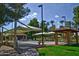 Scenic park with covered picnic areas, lush grass, and paved walking paths at 17162 N Winding Trl, Surprise, AZ 85374
