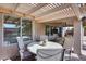 Inviting covered patio with an open pergola, featuring a dining table and additional seating area at 17162 N Winding Trl, Surprise, AZ 85374