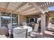Inviting covered patio with an open pergola, featuring a dining table and additional seating area at 17162 N Winding Trl, Surprise, AZ 85374