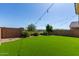Beautiful backyard featuring green lawn, brick wall, and stylish string lights at 17425 W Willow Ave, Surprise, AZ 85388