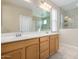 Bathroom features a double sink vanity with a large mirror and a tiled walk-in shower with glass enclosure at 17425 W Willow Ave, Surprise, AZ 85388