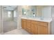 Bathroom with a double sink vanity, tile flooring, and a view into the bedroom with carpet at 17425 W Willow Ave, Surprise, AZ 85388