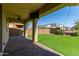 Covered patio featuring brick floors, ceiling fan, and a view of the backyard with artificial grass at 17425 W Willow Ave, Surprise, AZ 85388