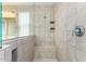 Tiled walk-in shower with built-in seating, shower caddy, and glass partition at 17425 W Willow Ave, Surprise, AZ 85388