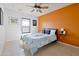 Bright bedroom featuring a ceiling fan, large window, and a modern accent wall to add style to the space at 1810 N Sunaire Cir, Mesa, AZ 85205
