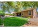 Lush backyard with a well-manicured lawn, mature trees, and a cozy patio area, perfect for outdoor living at 18492 E Oak Hill Ln, Queen Creek, AZ 85142