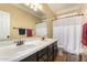 Bathroom with double sinks, white countertops, vanity with dark wood cabinetry, and a shower at 18492 E Oak Hill Ln, Queen Creek, AZ 85142