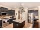 Spacious kitchen with modern appliances, dark cabinets, an island, and tile flooring at 18492 E Oak Hill Ln, Queen Creek, AZ 85142