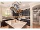 Kitchen with dark cabinetry, stainless steel appliances, an island, and tile backsplash at 18492 E Oak Hill Ln, Queen Creek, AZ 85142
