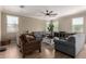 Inviting living room featuring neutral walls, stylish furniture, ceiling fan, and wood-look tile flooring at 18492 E Oak Hill Ln, Queen Creek, AZ 85142