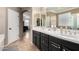 Bright bathroom featuring dual sinks with black cabinetry and tile floors at 18492 E Oak Hill Ln, Queen Creek, AZ 85142