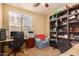 Bright office with natural light from large window, comfortable chair, and built in shelving at 18492 E Oak Hill Ln, Queen Creek, AZ 85142