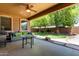 Inviting covered patio with outdoor seating and a view of the landscaped backyard at 18492 E Oak Hill Ln, Queen Creek, AZ 85142