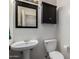 Cozy powder room with pedestal sink and black cabinets for extra storage at 18492 E Oak Hill Ln, Queen Creek, AZ 85142
