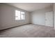 Bedroom showcases neutral carpet, bright walls, window, and a door to the hallway at 1917 S 246Th Ln, Buckeye, AZ 85326