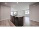 Kitchen island features granite countertops, undermount sink, dark cabinets, and tile flooring at 1917 S 246Th Ln, Buckeye, AZ 85326