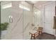 Glass-enclosed shower with marble walls featuring a built-in bench and a high window for natural light at 1919 W Plum Rd, Phoenix, AZ 85085