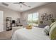 Sunlit bedroom featuring large windows, a ceiling fan, decorative shelving, and neutral decor at 1919 W Plum Rd, Phoenix, AZ 85085
