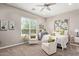 Cozy bedroom with two lounge chairs, a ceiling fan, and a large window providing natural light at 1919 W Plum Rd, Phoenix, AZ 85085