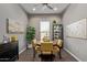 Cozy dining room with a modern light fixture, artwork, a display cabinet and a bright window at 1919 W Plum Rd, Phoenix, AZ 85085
