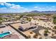 Expansive aerial view of desert home with a tile roof, pool, large lot and mountain views in the distance at 20041 W Colter St, Litchfield Park, AZ 85340