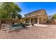 Spacious backyard with a sparkling pool, covered patio, and manicured landscaping offers a perfect space for outdoor entertaining at 20709 W Delaney Dr, Buckeye, AZ 85396