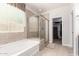 Well-lit bathroom featuring a tub with shower, tiled walls, and natural light at 20709 W Delaney Dr, Buckeye, AZ 85396