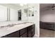 Bathroom showcasing a double sink vanity with black cabinets and decorative tile accents at 20709 W Delaney Dr, Buckeye, AZ 85396