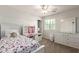 Well-lit bedroom with a ceiling fan, large mirror, workstation, and a theme bedspread at 20709 W Delaney Dr, Buckeye, AZ 85396