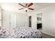 Bedroom with a ceiling fan, connecting doors to a bathroom and hallway and carpeted floors at 20709 W Delaney Dr, Buckeye, AZ 85396