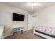 Clean bedroom featuring a ceiling fan, mounted TV, colorful storage and connecting doors at 20709 W Delaney Dr, Buckeye, AZ 85396