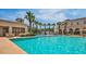 Resort-style community pool featuring palm trees and splash pad at 20709 W Delaney Dr, Buckeye, AZ 85396