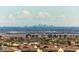 Expansive view featuring the distant city skyline, residential rooftops, and natural landscape at 20709 W Delaney Dr, Buckeye, AZ 85396