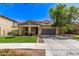 Charming home with two-car garage, covered porch, desert landscaping, and a lush green lawn at 20709 W Delaney Dr, Buckeye, AZ 85396