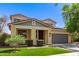 Charming two-story home featuring a gray two-car garage, solar panels, desert landscaping, and a covered porch at 20709 W Delaney Dr, Buckeye, AZ 85396