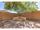 Cozy firepit area with a unique corner bench and paved patio provides a private and inviting outdoor gathering space at 20709 W Delaney Dr, Buckeye, AZ 85396