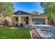 Charming single-story home with a well-maintained lawn, mature trees, and a welcoming front entrance at 20709 W Delaney Dr, Buckeye, AZ 85396