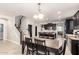 Dining area in an open-concept kitchen with dark cabinets and a modern chandelier at 20709 W Delaney Dr, Buckeye, AZ 85396