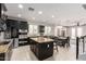 A modern kitchen featuring dark cabinets, a center island, and stainless steel appliances at 20709 W Delaney Dr, Buckeye, AZ 85396